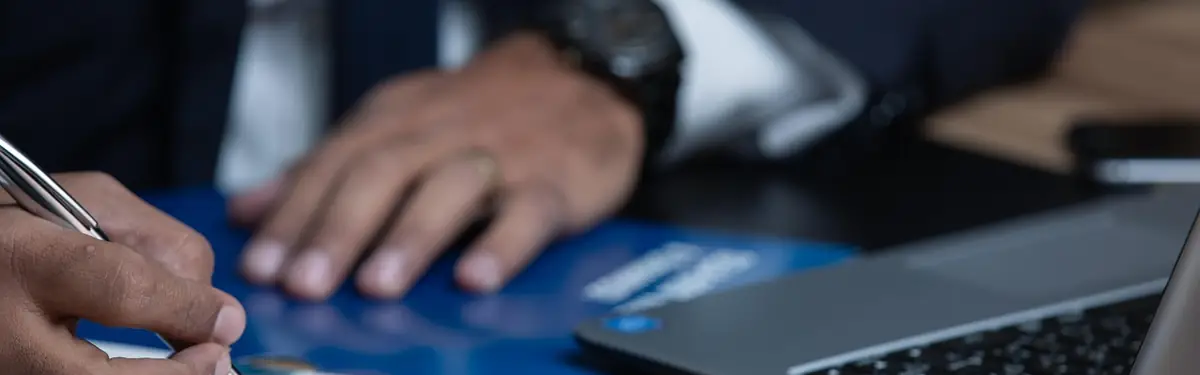 Formulaire administratif rempli &agrave; la main &agrave; c&ocirc;t&eacute; d&rsquo;un ordinateur portable
